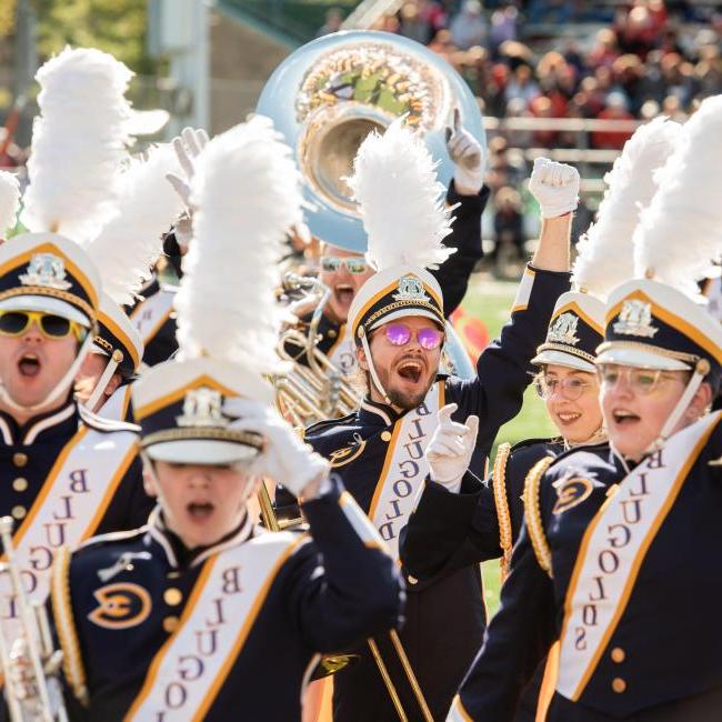 Blugold Marching Band members cheer at a football game